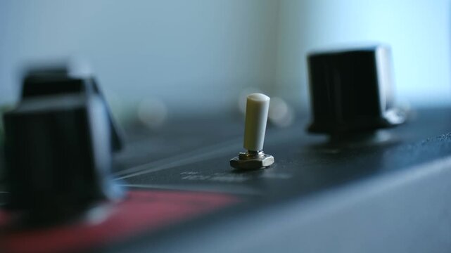 small switch click, vintage toggle operates with soft click, closeup of tiny mechanical switch, fingers activate miniature vintage toggle switch producing gentle clicking sound classic synthesizer
