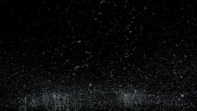 Super Slow Motion Shot of Real Raindrops Falling on a Surface, Isolated on Black, at 1000fps