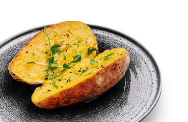 Baked potato served on a stylish black plate with herbs and spices