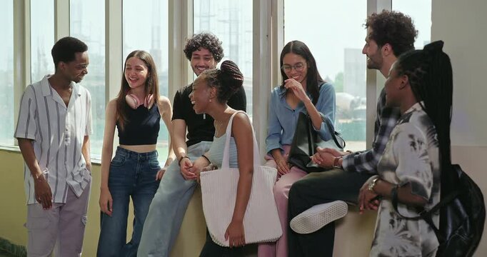 Indian young adult gen z happy boy girl pupil talk casual gossip share blab enjoy new day spend break time campus place African teen male female group team guys speak funny do joke have fun joy
