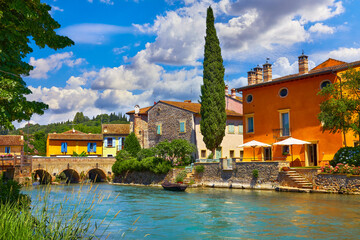Borghetto Valeggio sul Mincio, Verona, Italy. Italian traditional village vintage colorful houses above river. Stone bridge ancient architecture. Summer sunny day.