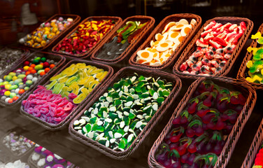 Assortment of colorful gummy candies in baskets.