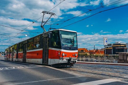 Classic red tram traveling in Prague city.