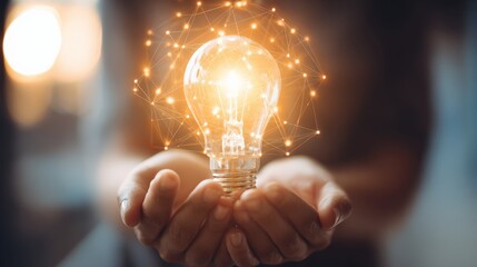 Innovative Idea: Person Holding a Glowing Light Bulb Representing Creativity and Inspiration in Technology