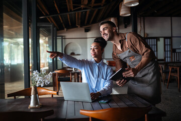 Obraz premium Restaurant manager and leader collaborating in modern cafe. Happy teamwork concept