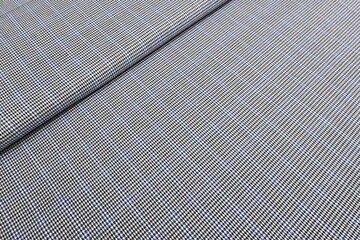 Striking black and white houndstooth fabric with a bold blue overcheck. Classic suiting wool textile ideal for contemporary tailored suits, jackets and sophisticated fashion statements. 