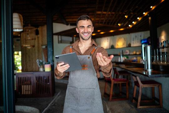 Confident cafe, restaurant owner standing with arms crossed, welcoming customers to coffee shop