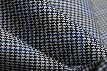 Striking black and white houndstooth fabric with a bold blue overcheck. Classic suiting wool...