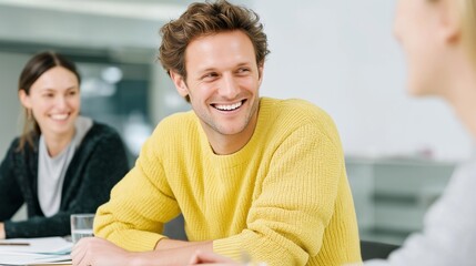 In a bright office setting, three workers engage in a cheerful conversation, exchanging ideas and laughter. Their positive energy creates a collaborative atmosphere for teamwork