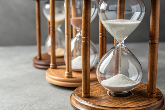 hourglass on a wooden background - Powered by Adobe
