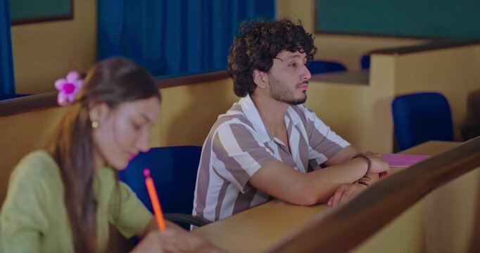 Indian young adult gen z dull lazy tired male man do yawn feel bad lack of energy fall asleep take nap on desk table. Teen pupil girl learn study hold pencil writing new exam notes class room place