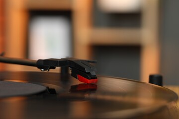 Modern turntable with vinyl record at home, closeup. Space for text