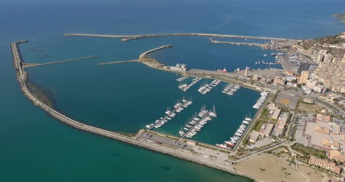 Aerial view of the port of Licata, located in the province of Agrigento, Sicily, Italy. It is a small harbor overlooking the blue waters of the Mediterranean Sea