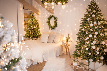 A cozy bedroom with a bed decorated with white bed linen. There is a Christmas tree with garlands in the corner. 
