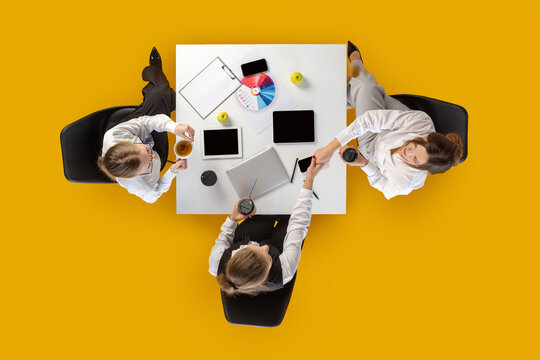 Team shaking hands and checking devices during work session. Concept of HR visuals, corporate communication, business workflow and social media content.