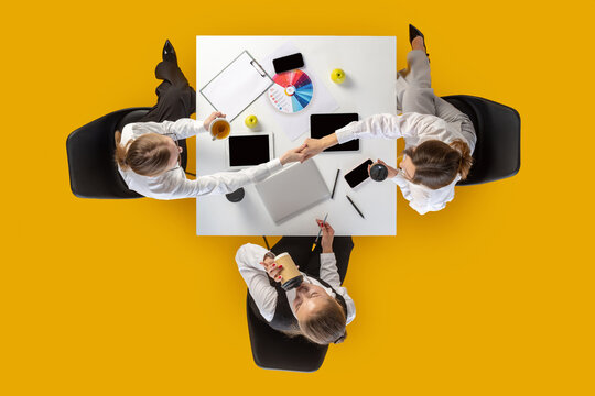 Business team discussing color chart and devices during coffee break in overhead angle. Concept of marketing content, office routines, education materials and corporate communication.