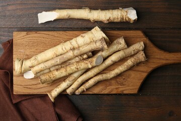 Fresh raw horseradish roots on wooden table, top view