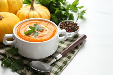 Tasty pumpkin cream soup served on white table, closeup. Space for text