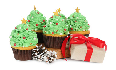 Christmas tree shaped cupcakes, pine cones and gift box isolated on white