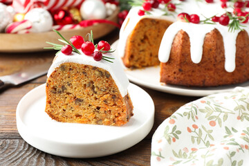 Slice of tasty Christmas cake with cranberries served on wooden table, closeup