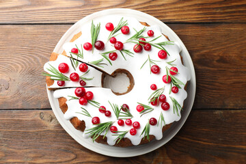 Tasty Christmas cake with cranberries on wooden table, top view
