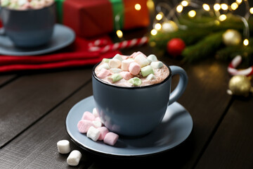 Tasty hot cocoa drink with marshmallows in cup on dark wooden table, closeup