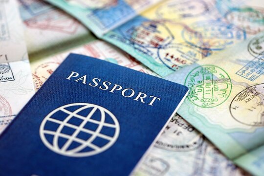 Many open passport pages with lots of visas and entrance stamps from various countries passport control. Concept of travel and tourism worldwide - Powered by Adobe