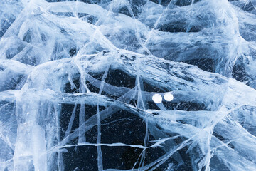Unusual nice natural blue ice texture of frozen Baikal Lake in cold winter day. Nature abstract pattern of white cracks and bubbles. Winter background, mock up, flat lay, blank, close-up, top view