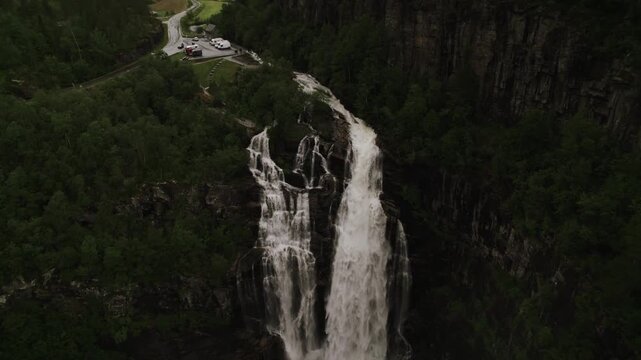 Aerial view of the Skjervefossen waterfall, a stunning cascade of rushing water amidst lush green forest, Granvin, Vestland, Norway.
