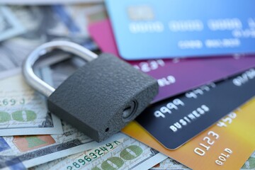 One hundred US dollar bill banknotes and credit cards with padlock. Concept of security and safe banking