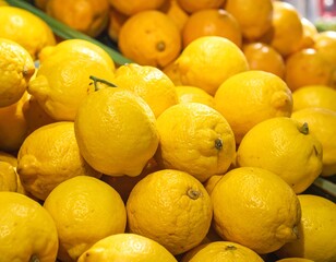 Close-up of a vibrant assortment of citrus fruit. The composition highlights textured skin and a bright yellow hue