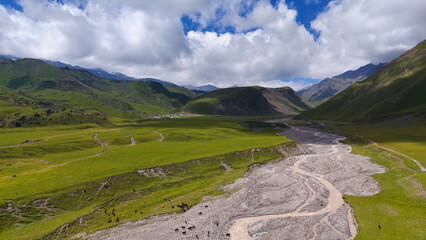 a drone flies over a mountain river in a mountain gorge in the valley of marmots in the Dzhily-Su tract in the Caucasus at the foot of Elbrus