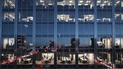 Office Building at Night: Workers, City Lights, and Reflections