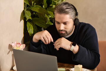 Mature man in stylish attire enjoys time working, wearing headphones at a cozy setting
