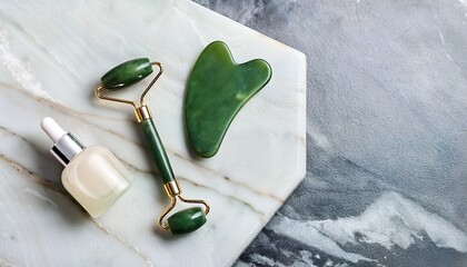 jade facial roller and gua sha tool on marble