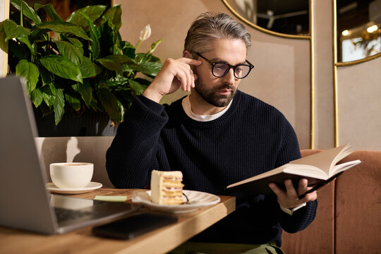 Charming man enjoying a quiet afternoon reading in a cozy cafe