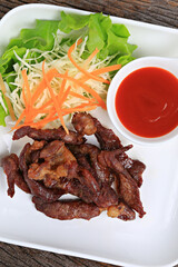 Fried Sun-Dried Beef garnished with shredded cabbage and carrots, Food photography for use in menus