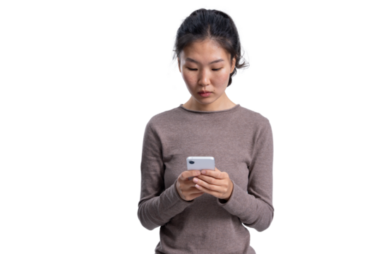 Young Asian woman wearing casual sweater holding smartphone, standing and focused, isolated on white background, useful for collage or template