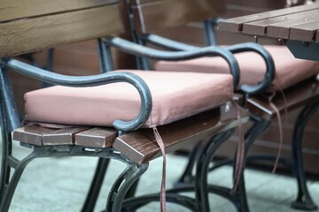 A soft pink waterproof fabric cushion on a bench in an outdoor cafe for guest comfort