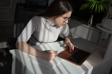 Young woman studying with laptop at desk