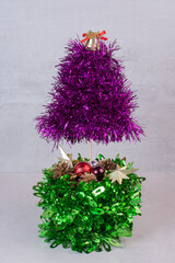 Sparkling tinsel tree decoration with purple and green layers