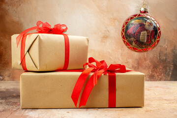 Festive christmas gifts wrapped in kraft paper with red ribbons and a hanging ornament