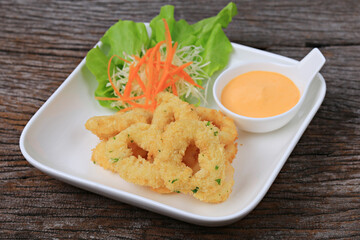 Breaded calamari with tartar sauce decorated on a black plate, Calamari with Herbal Tartar Sauce