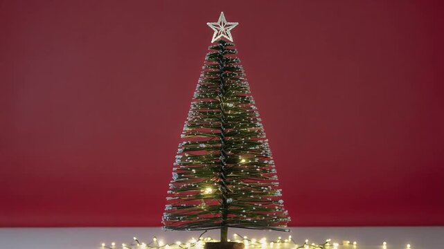 fondo de color rojo intenso y profundo, que evoca una noche invernal o un cielo estrellado. En el centro, o de manera prominente, se distingue la silueta de un abeto navide&ntilde;o. 