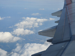 An airplane wing in the sky above the clouds