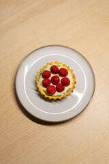 A plate of matcha white chocolate raspberry tart.