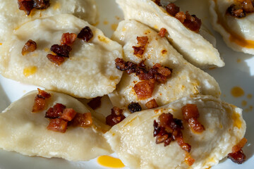 Traditional Polish pierogi with fried bacon bits, close-up
