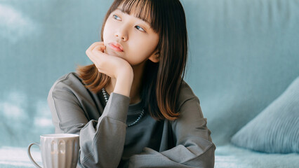 肘をついて考えごとをする女性