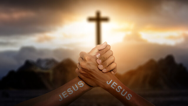 Human hands with Jesus text joined together with a Christian cross on the hill with dark dramatic sky background. Concept of Christianity, religious, faith, Jesus, or belief - Powered by Adobe