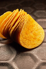 Close-up of several potato chips on a black baking tray